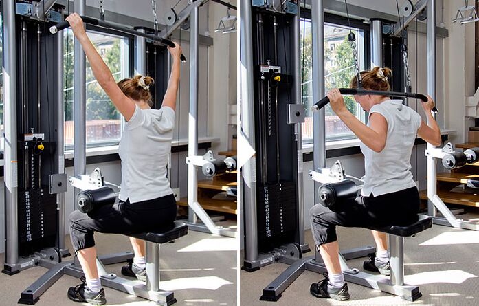 Ciągnięcie klocka za plecami na symulatorze pomaga wypracować mięśnie najszersze grzbietu